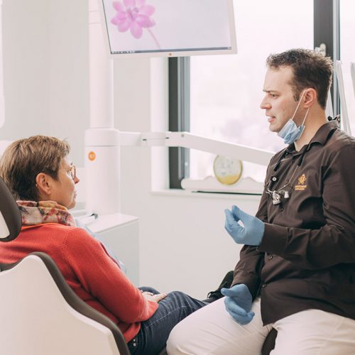 Dr. Andreas Euchner berät Patientin zur Schnarchtherapie mit Schnarchschiene im Mund.