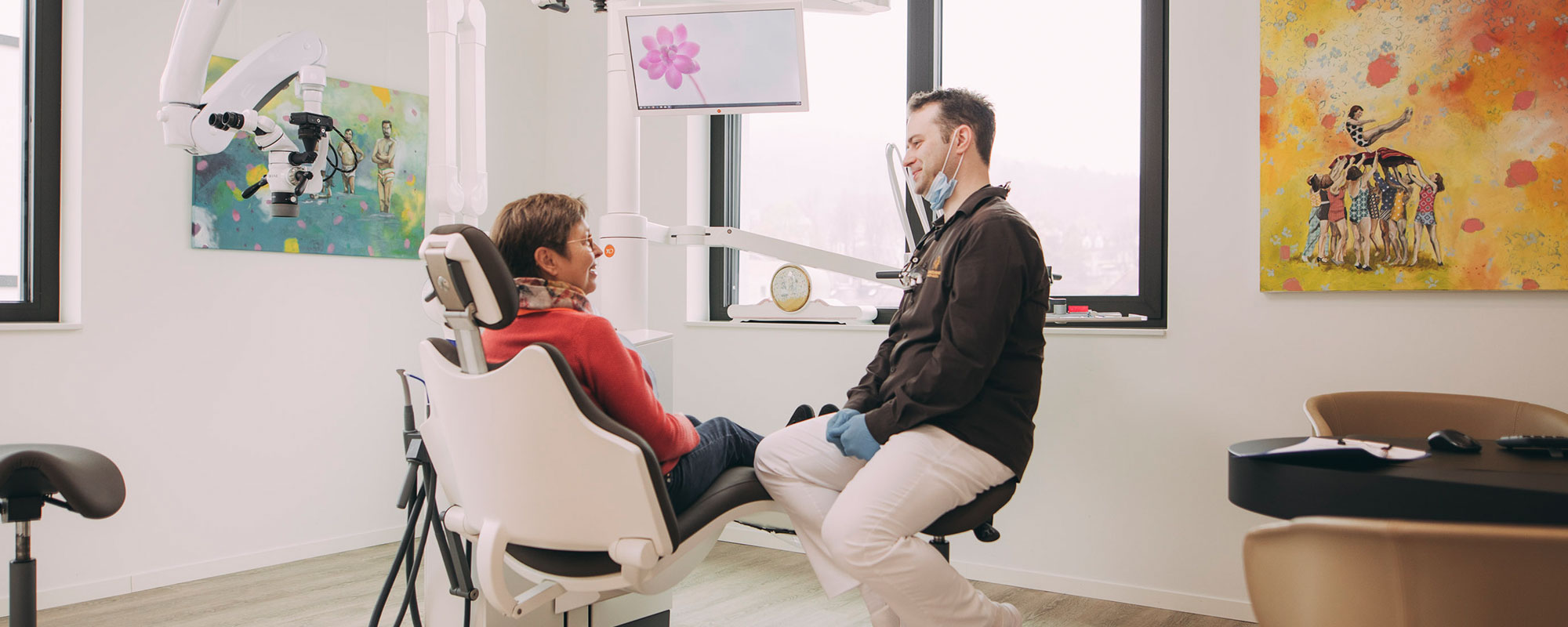 Zahnarzt berät Patientin im modernen Behandlungsraum
